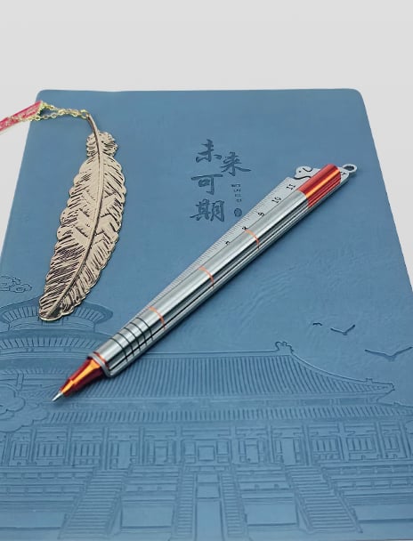 The pen bay with a notebook and a metal bookmark